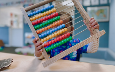 Child playing with an abacus at Little Wonders Timaru