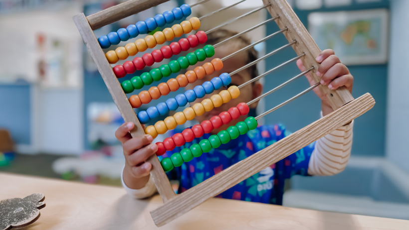 Child playing with an abacus at Little Wonders Timaru