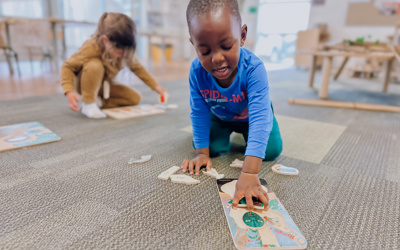 Two children playing with puzzles in before school room at little Wonders Timaru