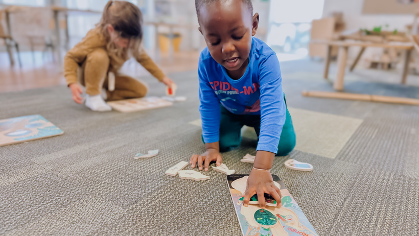 Two children playing with puzzles in before school room at little Wonders Timaru